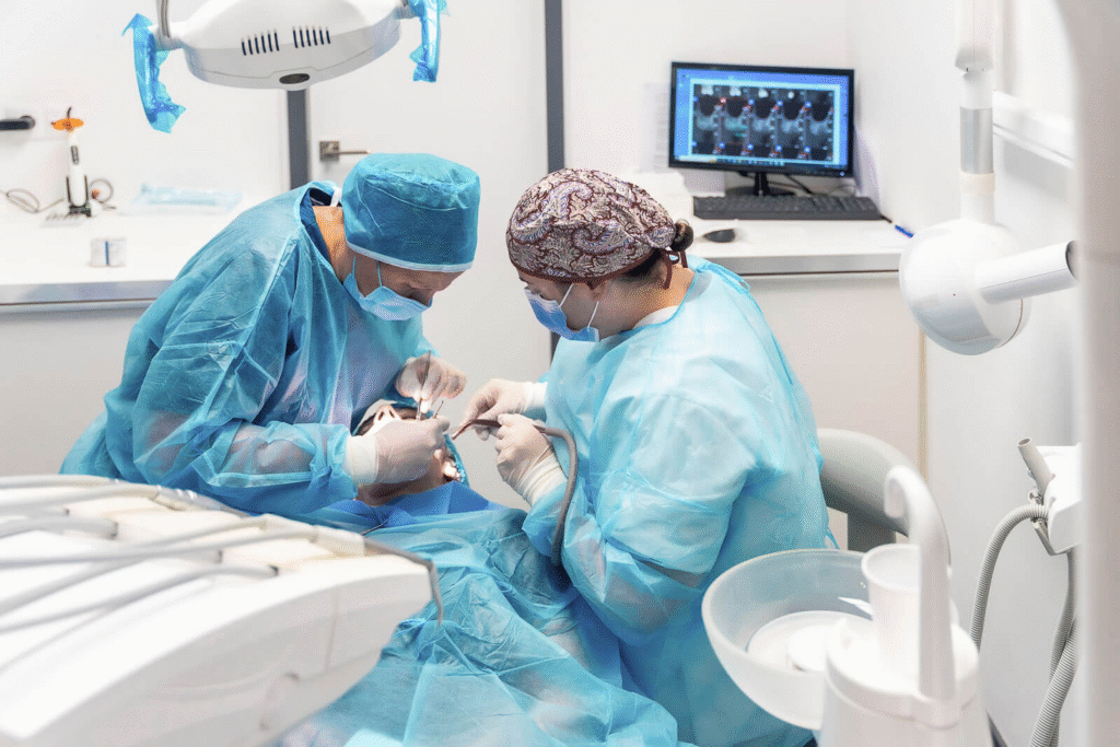 Dentists doing dental surgery in a clinic using modern tools and wearing safety gear